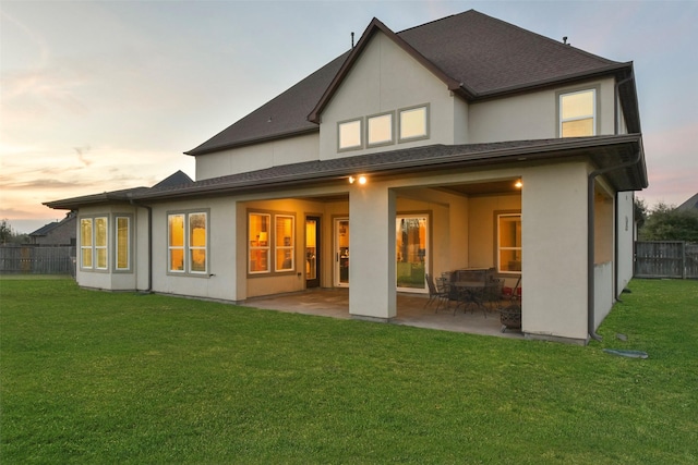 6919 Champion Trl, Katy, TX 77493 - back of property at dusk featuring stucco siding and a patio area