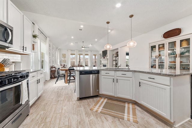20710 Kings Timber Trl, Humble, TX 77346 - kitchen with stainless steel appliances, a ceiling fan, white cabinets, a sink, and light stone countertops