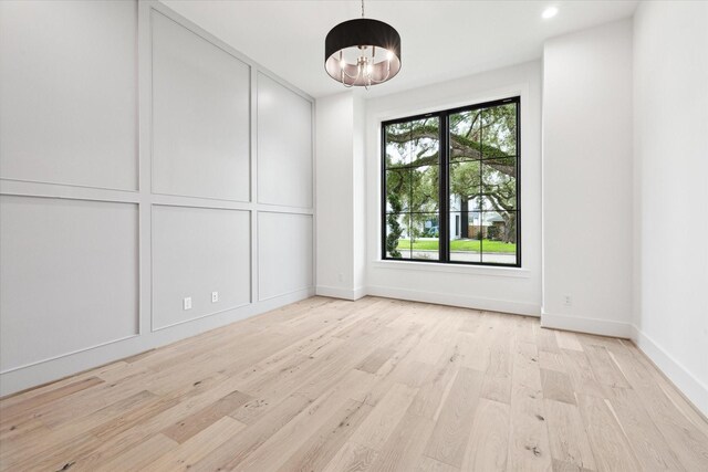 4706 Waring St, Houston, TX 77027 - unfurnished room featuring a chandelier, light wood-type flooring, and baseboards