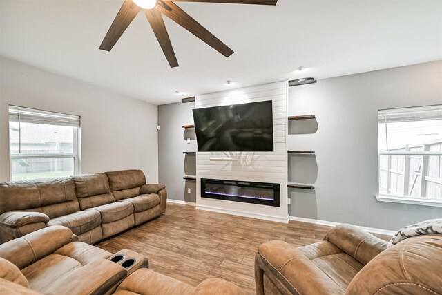 12750 Tullich Ln, Humble, TX 77346 - living area with a ceiling fan, wood finished floors, baseboards, and a large fireplace