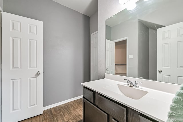 12750 Tullich Ln, Humble, TX 77346 - bathroom featuring wood finished floors, baseboards, and vanity