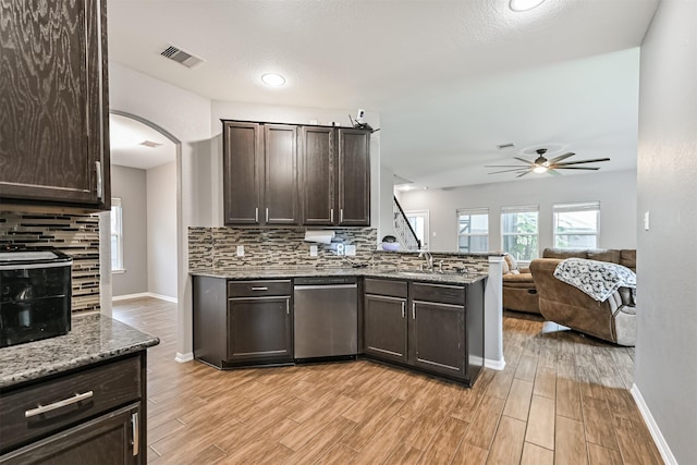 12750 Tullich Ln, Humble, TX 77346 - kitchen featuring stainless steel dishwasher, a ceiling fan, dark brown cabinetry, backsplash, and a peninsula