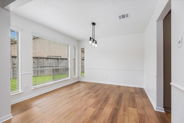 unfurnished dining area featuring wood finished floors and baseboards