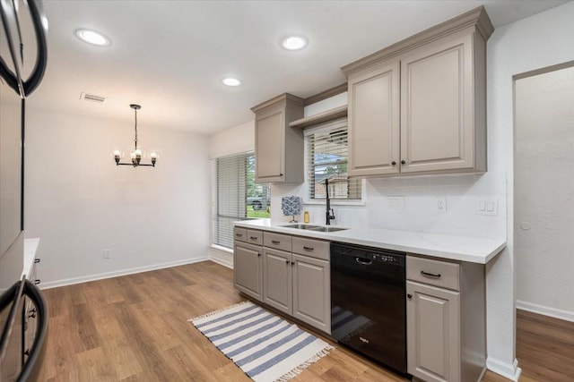 kitchen with dishwasher, a sink, gray cabinetry, light countertops, and light wood-style floors