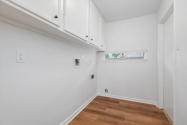 clothes washing area featuring washer hookup, cabinet space, wood finished floors, baseboards, and hookup for an electric dryer