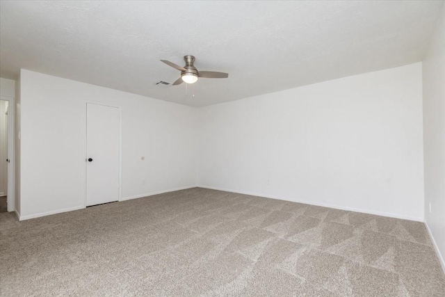spare room with a ceiling fan, carpet flooring, and baseboards
