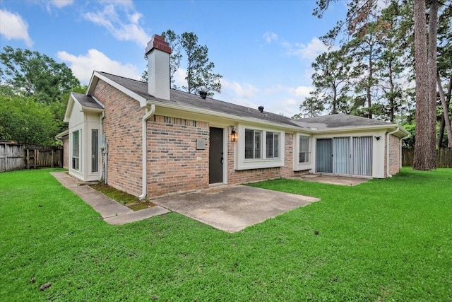 rear view of property with a patio area, brick siding, and a chimney