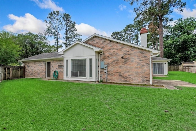 rear view of property with a chimney and brick siding