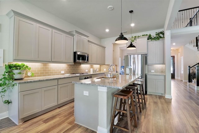 27163 Allenby Park Dr, Magnolia, TX 77354 - kitchen with appliances with stainless steel finishes, a sink, light wood-style flooring, decorative backsplash, and recessed lighting