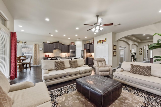 19914 Philippa Hills Trl, Cypress, TX 77433 - living area featuring arched walkways, dark wood finished floors, ceiling fan, and recessed lighting