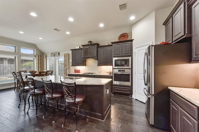 19914 Philippa Hills Trl, Cypress, TX 77433 - kitchen with appliances with stainless steel finishes, a sink, dark wood-style floors, dark brown cabinetry, and lofted ceiling