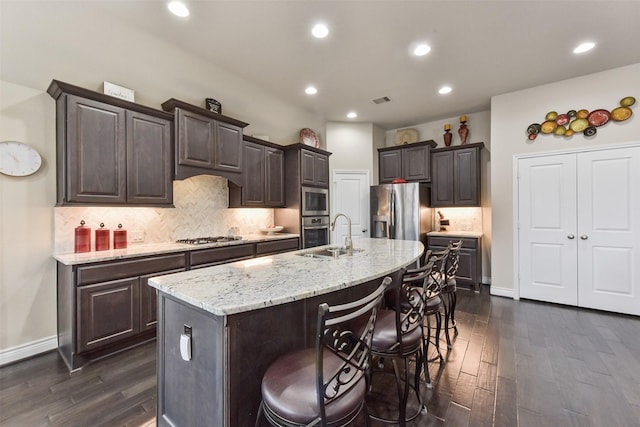 19914 Philippa Hills Trl, Cypress, TX 77433 - kitchen with appliances with stainless steel finishes, a sink, dark wood-style flooring, dark brown cabinetry, and recessed lighting