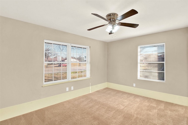 unfurnished room with carpet, healthy amount of natural light, and a ceiling fan