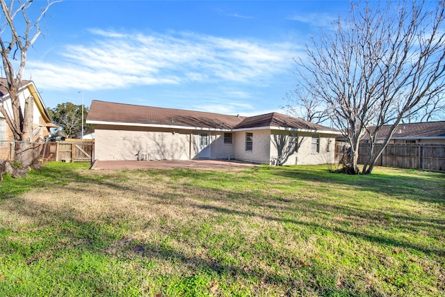 rear view of property with a gate, brick siding, and a patio area