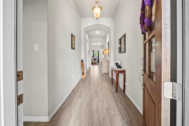 17214 Sequoia Kings Dr, Humble, TX 77346 - hallway with arched walkways, baseboards, and light wood finished floors