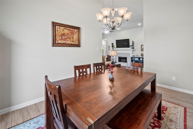 17214 Sequoia Kings Dr, Humble, TX 77346 - dining area featuring wood finished floors, baseboards, a chandelier, a fireplace, and recessed lighting