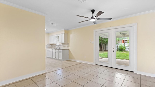 empty room with french doors, baseboards, light tile patterned floors, a ceiling fan, and crown molding