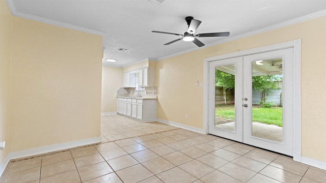 empty room featuring french doors, baseboards, crown molding, ceiling fan, and light tile patterned floors