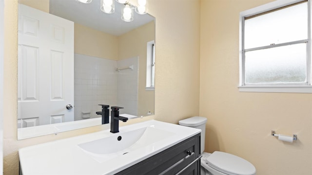 bathroom featuring toilet, a shower, vanity, and a chandelier
