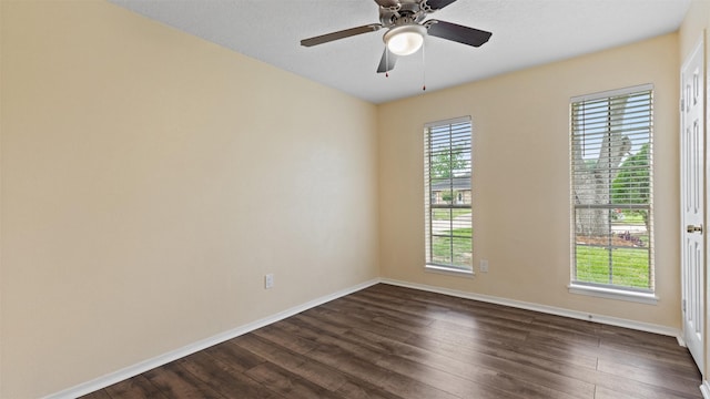 unfurnished room with dark wood finished floors, baseboards, and a ceiling fan