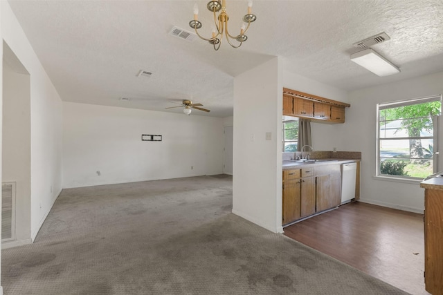 217 Lazy Ln, Conroe, TX 77301 - kitchen featuring white dishwasher, brown cabinetry, a sink, ceiling fan, and a textured ceiling