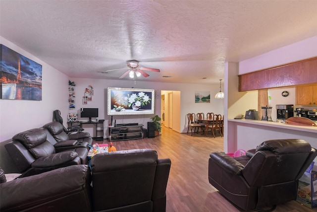 217 Lazy Ln, Conroe, TX 77301 - living room with wood finished floors, a ceiling fan, and a textured ceiling