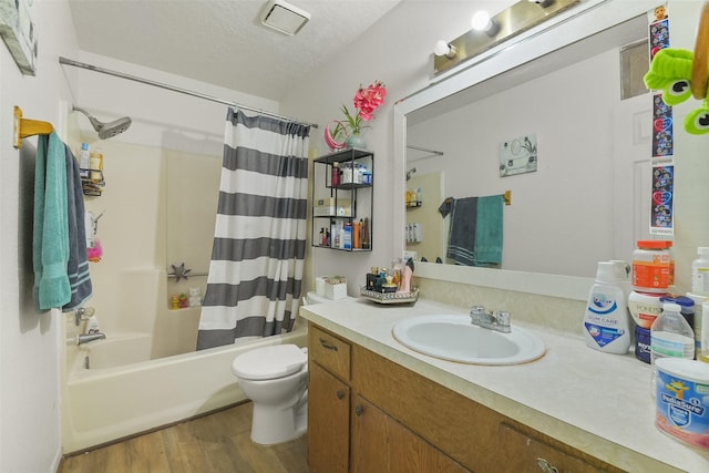 217 Lazy Ln, Conroe, TX 77301 - full bath featuring wood finished floors, toilet, vanity, shower / tub combo, and a textured ceiling