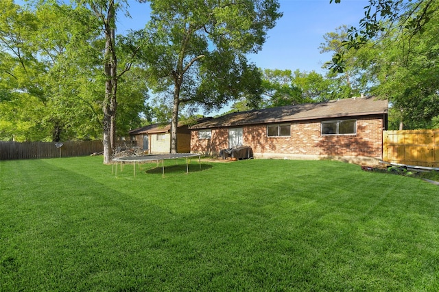 217 Lazy Ln, Conroe, TX 77301 - back of property featuring brick siding and a trampoline