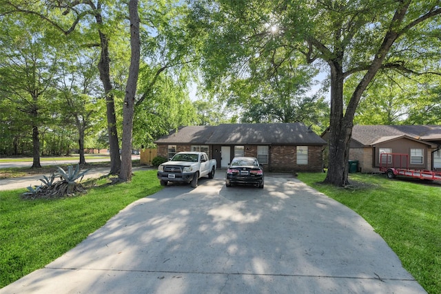 217 Lazy Ln, Conroe, TX 77301 - view of front of property featuring driveway, a front yard, and brick siding