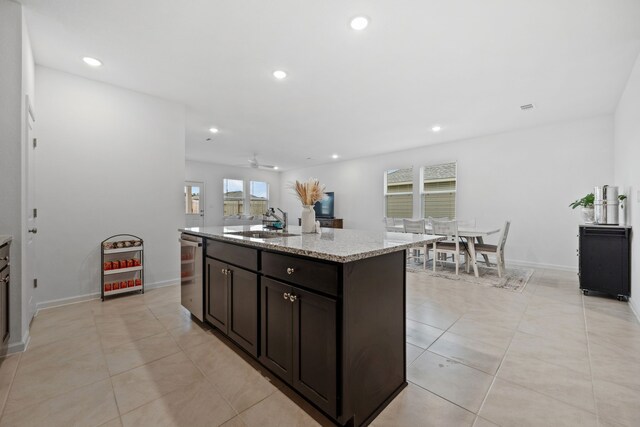 kitchen with stainless steel dishwasher, a sink, recessed lighting, light tile patterned floors, and a center island