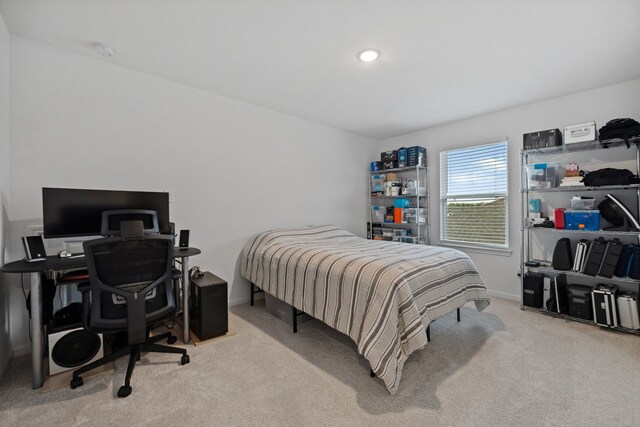 carpeted bedroom featuring a desk and baseboards