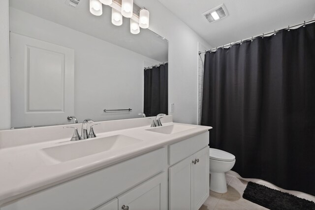 bathroom featuring toilet, tile patterned flooring, and double vanity