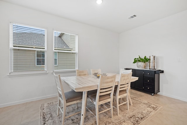 dining space with baseboards and light tile patterned floors
