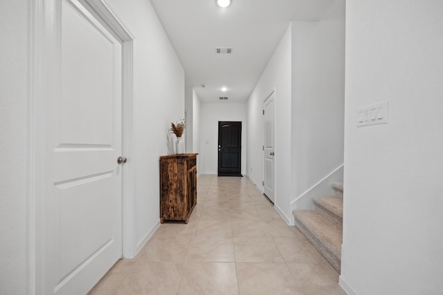 corridor with light tile patterned floors, recessed lighting, stairway, and baseboards