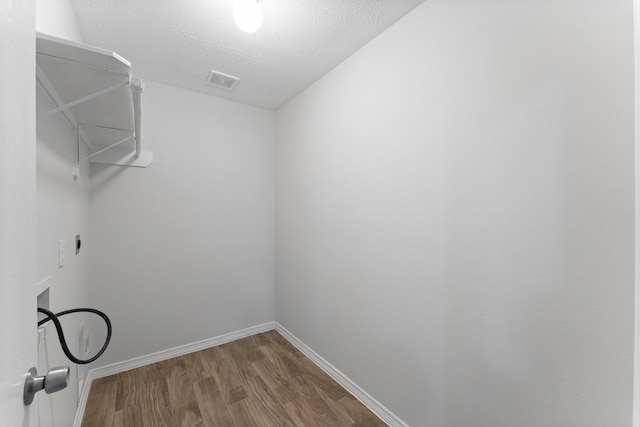 washroom featuring hookup for a washing machine, wood finished floors, and baseboards