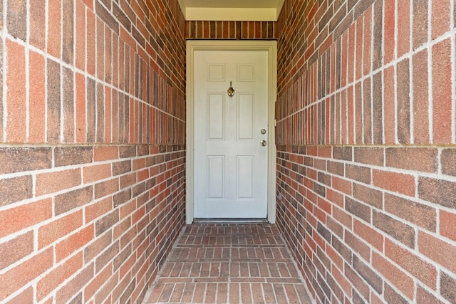view of exterior entry with brick siding