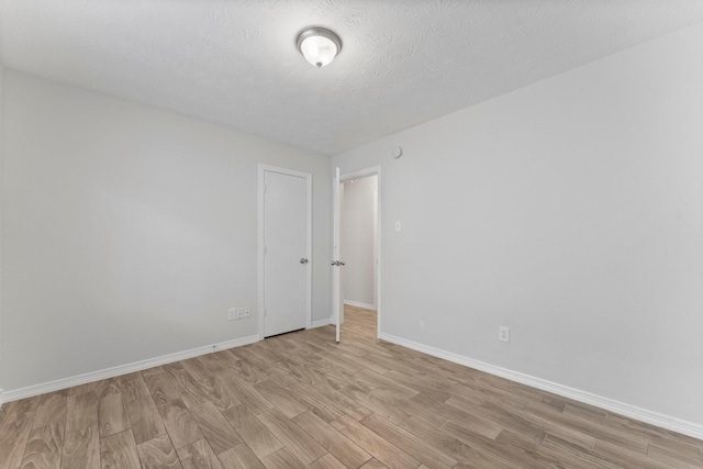 unfurnished room featuring light wood-type flooring and baseboards