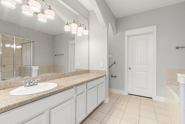 bathroom with tile patterned flooring, a garden tub, vanity, a shower stall, and a chandelier