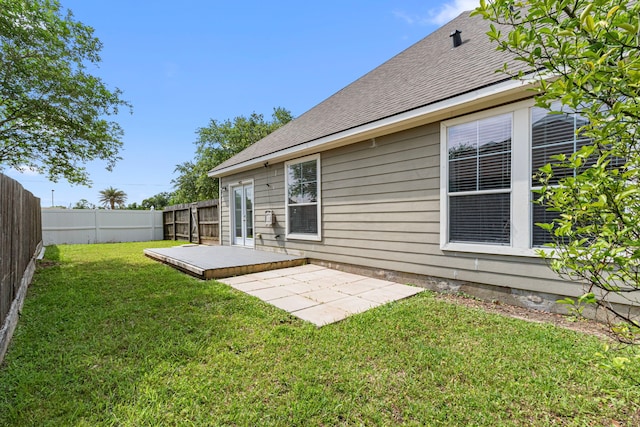 rear view of property with a patio area, roof with shingles, and french doors