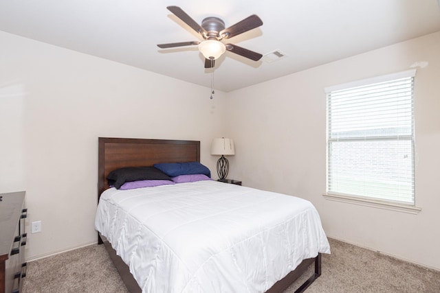 carpeted bedroom with multiple windows and a ceiling fan