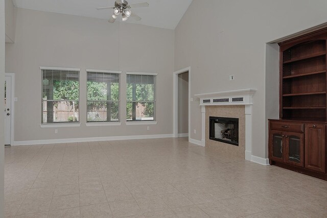 158 Hansom Trail St, The Woodlands, TX 77382 - unfurnished living room with high vaulted ceiling, ceiling fan, a tile fireplace, and baseboards