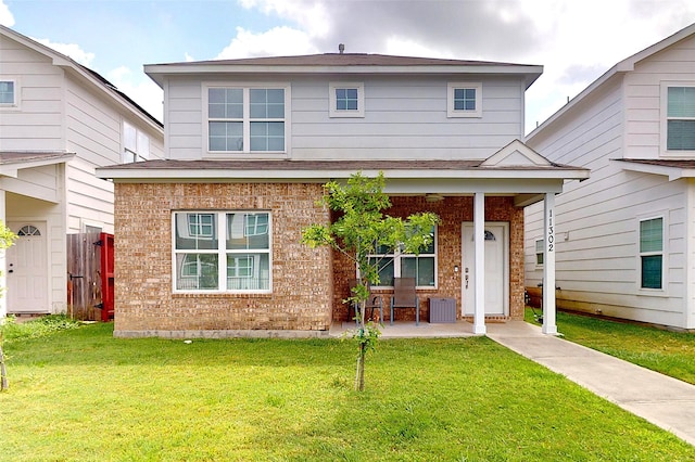 view of front facade with brick siding, a front yard, and cooling unit