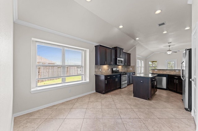 2043 Plum Rose Ln, Richmond, TX 77469 - kitchen with stainless steel appliances, tasteful backsplash, vaulted ceiling, a ceiling fan, and light tile patterned flooring