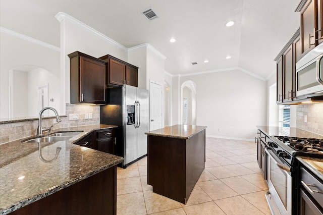 2043 Plum Rose Ln, Richmond, TX 77469 - kitchen featuring arched walkways, stainless steel appliances, a sink, dark stone countertops, and ornamental molding