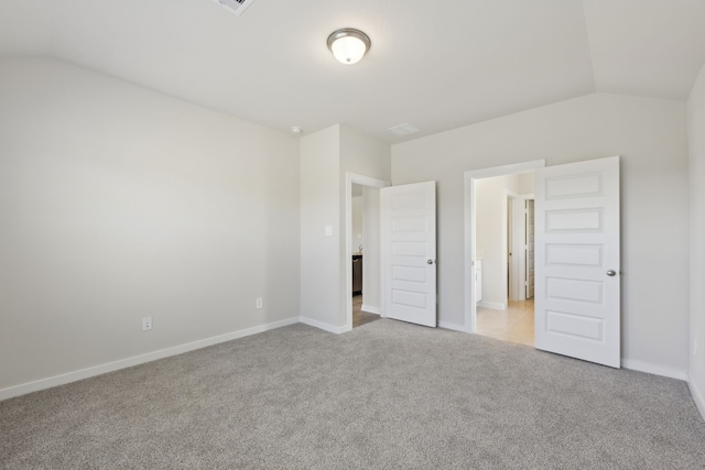 unfurnished bedroom featuring lofted ceiling, carpet floors, and baseboards
