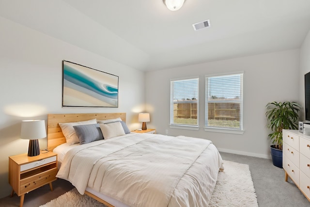 bedroom featuring light carpet, baseboards, and lofted ceiling