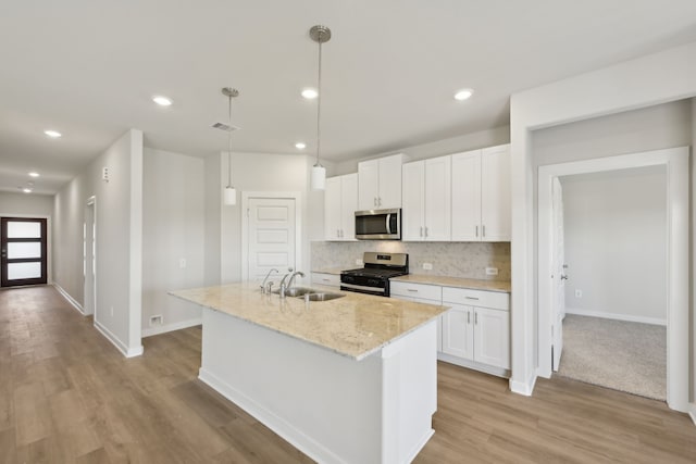 kitchen featuring stainless steel appliances, a sink, white cabinets, light wood-type flooring, and recessed lighting