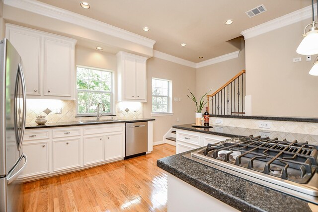 718 Roy St, Houston, TX 77007 - kitchen with dark countertops, light wood finished floors, appliances with stainless steel finishes, and a sink