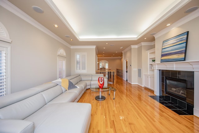 718 Roy St, Houston, TX 77007 - living area featuring a tray ceiling, light wood-style flooring, visible vents, built in features, and a tile fireplace