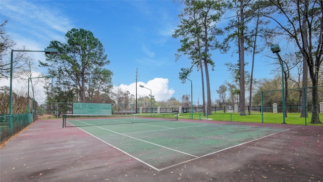 view of tennis court featuring fence